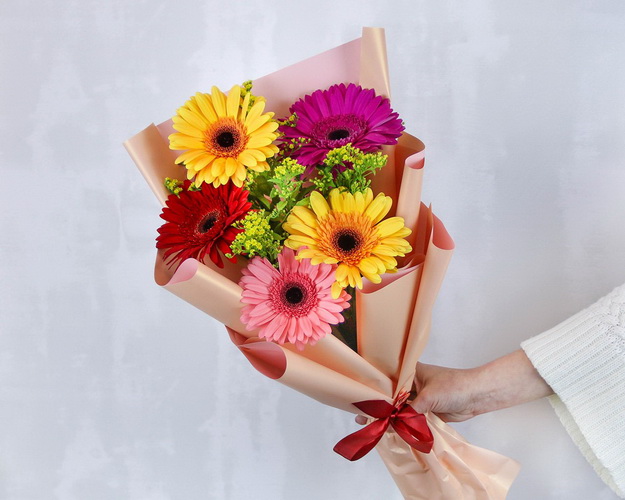 Букет з 5 гербер стандарт мікс у стильній упаковці із зеленню