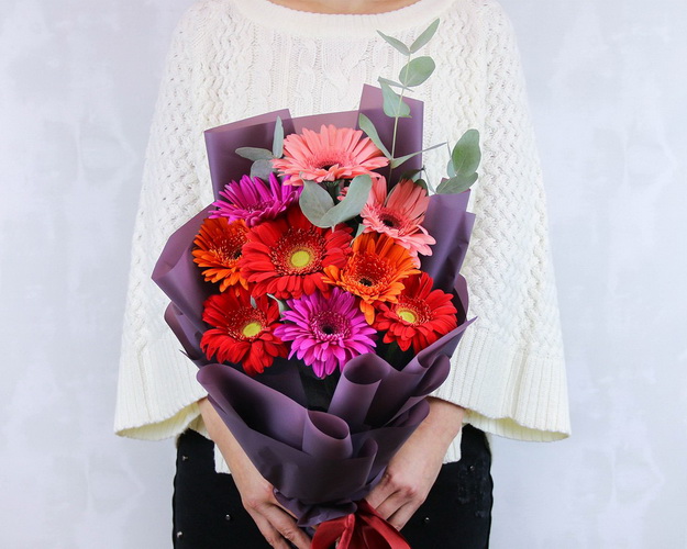 Букет з 9 гербер стандарт мікс у стильній упаковці із зеленню