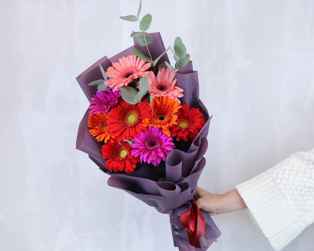 Букет з 9 гербер стандарт мікс у стильній упаковці із зеленню