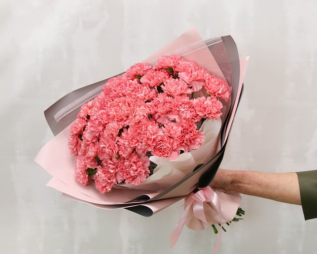 Букет із 35 рожевих гвоздик у стильній упаковці.
