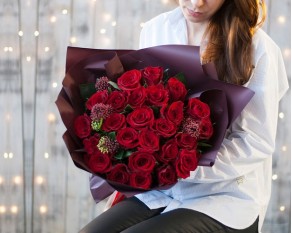 Букет з 25 червоних троянд із зеленню в упакуванні