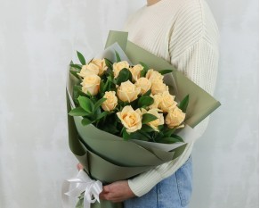 Букет із 15 кремових троянд із зеленню в упакуванні