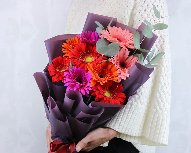 Букет з 9 гербер стандарт мікс у стильній упаковці із зеленню