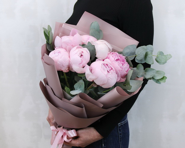 Букет з 7 рожевих півоній із зеленню в стильній упаковці