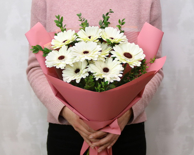 Букет із 9 білих міні гербер у стильній упаковці із зеленню