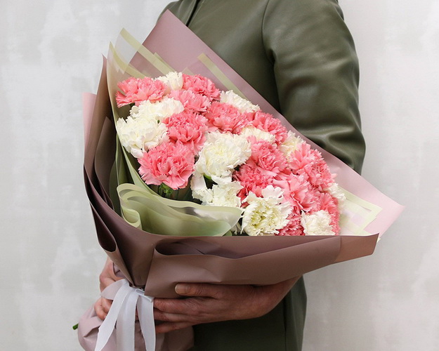 Букет із 25 рожевих та білих гвоздик у стильній упаковці.