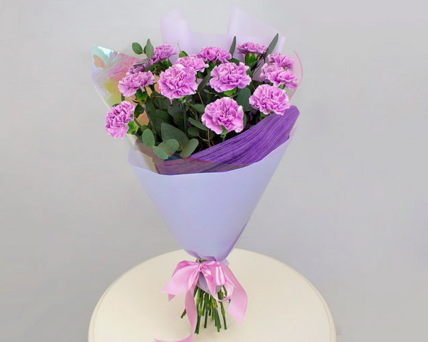 Букет із 13 місячної гвоздики з евкаліптом у фіолетовій упаковці.