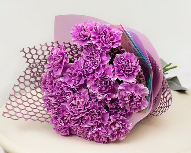 Букет із 21 місячної гвоздики у фіолетовій упаковці.
