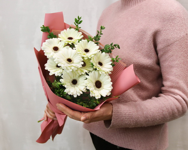 Букет із 9 білих міні гербер у стильній упаковці із зеленню