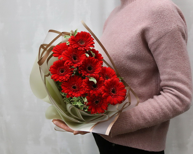 Букет з 11 червоних міні гербер у стильній упаковці із зеленню