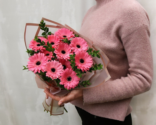 Букет із 11 рожевих міні гербер у стильній упаковці із зеленню