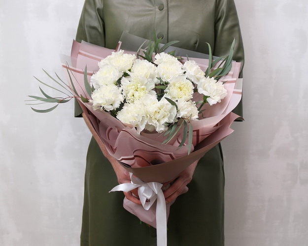 Букет із 15 білих гвоздик у стильній упаковці із зеленню