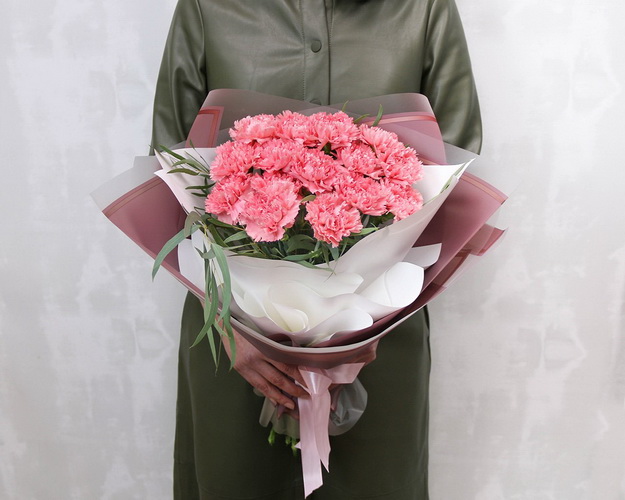 Букет із 15 рожевих гвоздик у стильній упаковці із зеленню