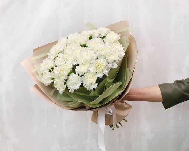 Букет із 25 білих гвоздик у стильній упаковці.