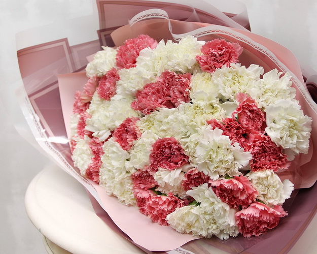 Букет із 51 рожевої та білої гвоздики у стильній упаковці.