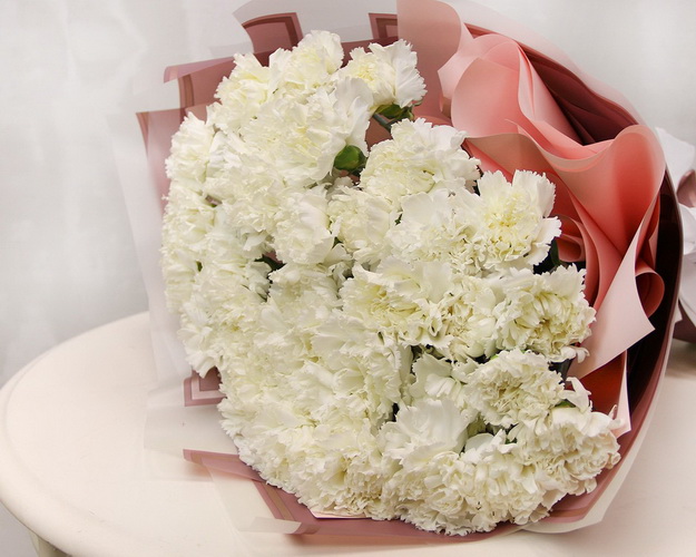 Букет із 35 білих гвоздик у стильній упаковці.