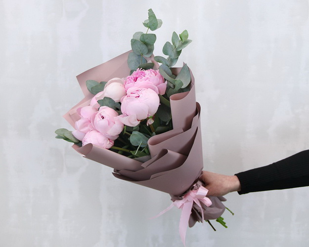 Букет з 7 рожевих півоній із зеленню в стильній упаковці
